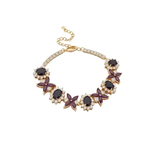 Elegante bracciale dorato con pietre nere ovali e fiori di zircone viola