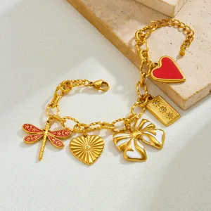 Gros plan du bracelet plaqué or avec des breloques de libellule rouge et nœud blanc.