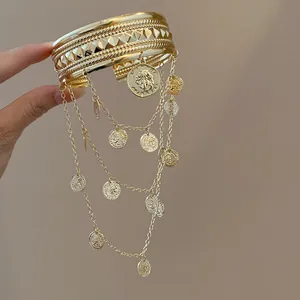 Vue détaillée d'un bracelet de bras doré avec chaînes et pendentifs de portrait ronds