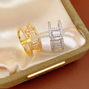 Gros plan de bagues ouvertes élégantes or et argent double couche avec zircon.