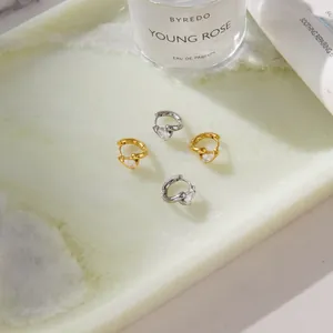 Close-up of elegant gold and silver stainless steel hoop earrings with teardrop zirconia