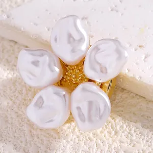 Vista macro de un elegante broche de flor de perlas con centro dorado sobre piedra