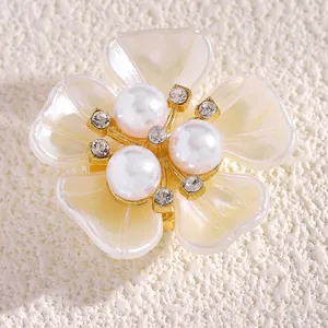 Detalle macro de un elegante gemelo de flor con perlas y diamantes de imitación dorados