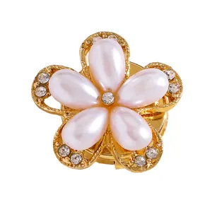 Vista detallada de un elegante gemelo de flor de perla con detalles dorados y pedrería brillante