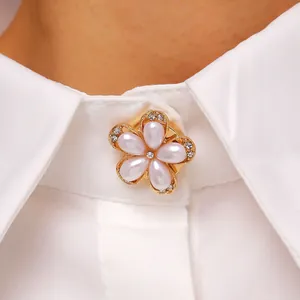 Primer plano de un elegante broche de flor de perlas en el cuello de una camisa blanca