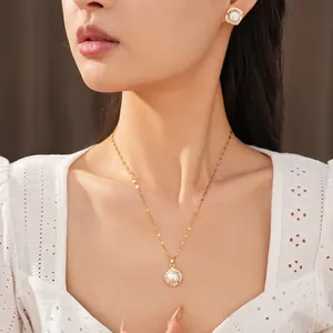 Close-up of elegant gold pearl jewelry set featuring necklace and stud earrings on model