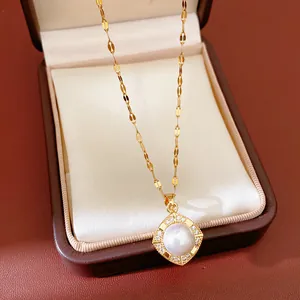 Detailed shot of a gold necklace with a square pearl and zircon pendant in a gift box