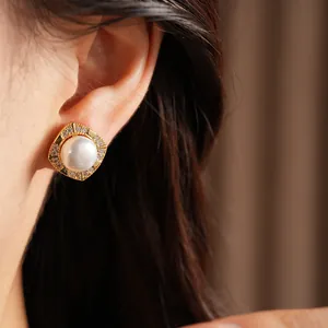Detailed view of elegant square gold-tone stud earring with large white pearl and zircons