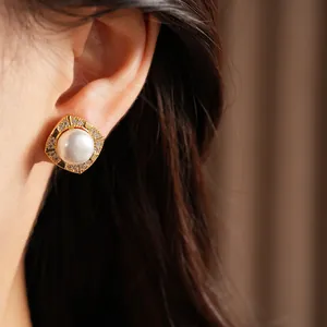 Elegant close-up shot of square gold-plated pearl stud earrings worn on model's ear