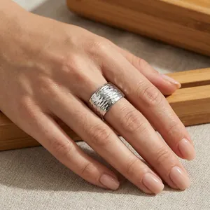 Vue détaillée de la texture martelée sur cette large bague minimaliste en titane.