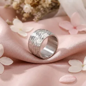Vue détaillée de la texture martelée à la main sur une bague large en acier titane argenté