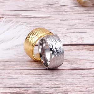 Gros plan de bagues en acier titane or et argent avec une texture martelée finie
