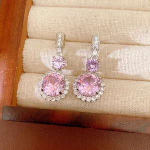 Boucles d'oreilles pendantes élégantes en zircon rose rond avec halo argenté étincelant