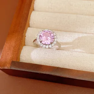 Détail macro d'une bague en argent ornée d'un grand zircon rose rond entouré de pierres claires.