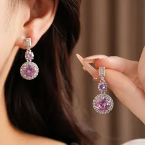 Gros plan détaillé montrant d'élégantes boucles d'oreilles rondes avec zircons roses