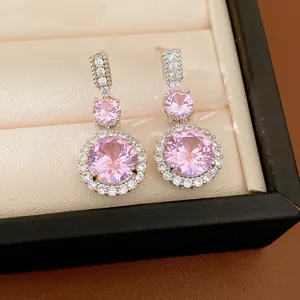 Vue détaillée de boucles d'oreilles pendantes en argent avec zircons roses ronds