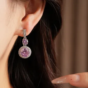 Gros plan détaillé de boucles d'oreilles pendantes avec élégants zircons roses ronds