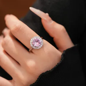 Vue détaillée d'une bague élégante avec une pierre rose ronde et un halo étincelant