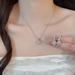 Détail d'un ensemble de luxe collier et boucles d'oreilles fleur en perles et zircon.