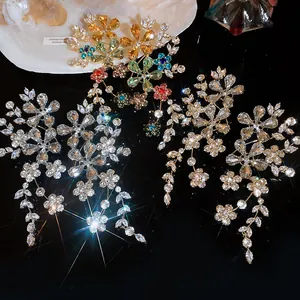 Détail de boucles d'oreilles fleuries évidées de luxe avec des strass colorés scintillants