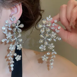 Vue détaillée de boucles d'oreilles en argent avec motif floral en strass.