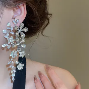 Détail de boucles d'oreilles fleurs en strass étincelants pour banquets élégants.