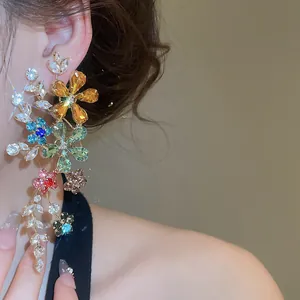 Gros plan exquis montrant les boucles d'oreilles pendantes en cristal multicolore portées