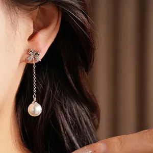 Élégantes boucles d'oreilles nœud en argent avec perles et zircons brillants