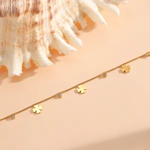 Detailansicht eines goldenen Titanstahl-Fußkettchens mit vierblättrigen Kleeblättern