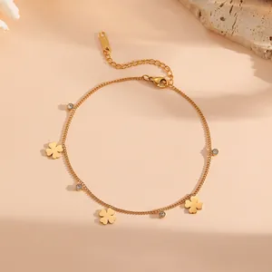 Detailansicht eines goldenen Edelstahl-Fußkettchens mit Kleeblatt-Anhängern und Kristallen