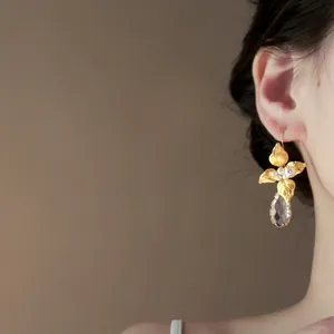 Eleganti orecchini a foglia d'oro con fiori, perle e una lucente goccia di cristallo