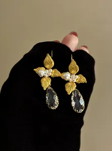 Eleganti orecchini vintage a foglia d'oro con cristalli neri a goccia e perle bianche.