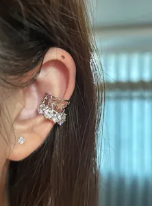 Primo piano di un elegante ear cuff in argento con stelle e zirconi