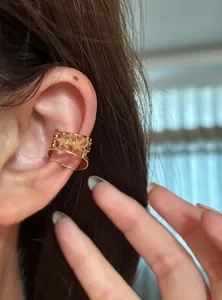 Elegante ear cuff dorato con motivo a stella per orecchie non forate su una modella