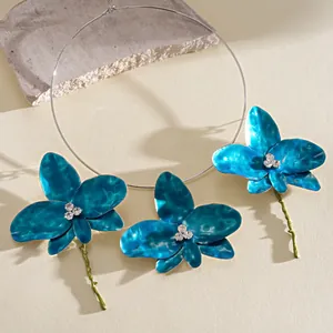 Retro blue enamel orchid necklace and earring set with rhinestones and green stems.