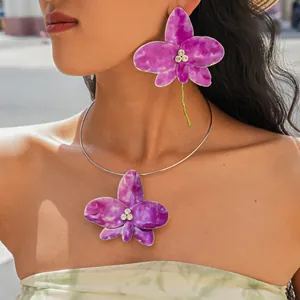 Detail view of exquisite purple enamel flower necklace and matching stud earrings on a model