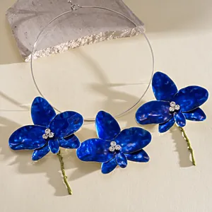 Detailed view of blue enamel orchid flowers with crystals on a choker and earring set