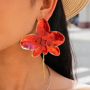 Close-up of vibrant red oil-dripped orchid earrings and minimalist silver metal neck collar