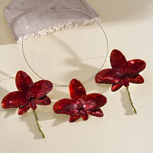 Detailed view of dark red enamel orchid choker with rhinestone centers and green stems