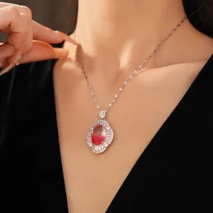 Exquisite palace style necklace featuring an oval red gemstone and zircon pendant on model