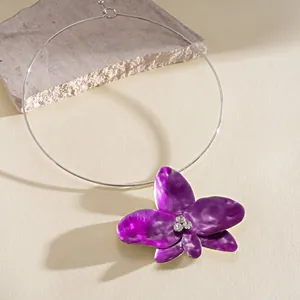 Detail of a purple floral choker necklace with sparkly rhinestones and silver band.