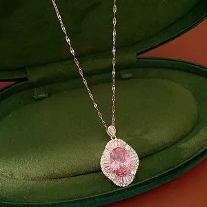 Detailed view of an elegant oval pink zircon necklace in a green velvet jewelry box