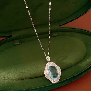 Elegant oval blue zircon necklace showcased inside a premium dark green velvet jewelry case.