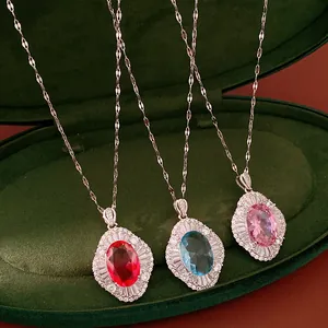 Detailed view of three vintage oval zircon necklaces in red, blue, and pink colors