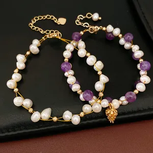 Close-up of freshwater pearl and amethyst bracelets with gold pineapple charm