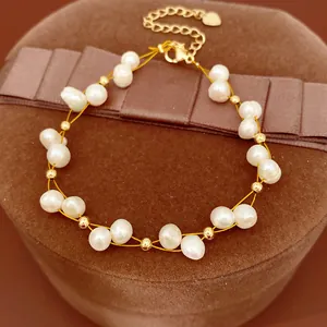 Close-up of elegant freshwater pearl bracelet with 18k gold-plated beads on velvet box.