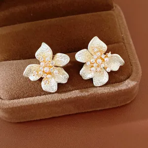 Detailed close-up view of elegant flower stud earrings with white petals and pearls
