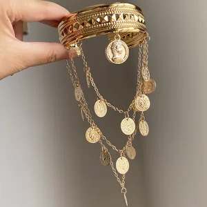 Gros plan détaillé d'un luxueux bracelet de bras en métal doré avec d'élégantes pièces pendantes