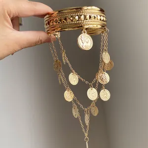 Vue détaillée du bracelet de bras en métal doré avec pendentifs pièces et franges