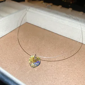 Gros plan d'un pendentif en cristal de cœur irisé facetté sur un fil de nylon transparent